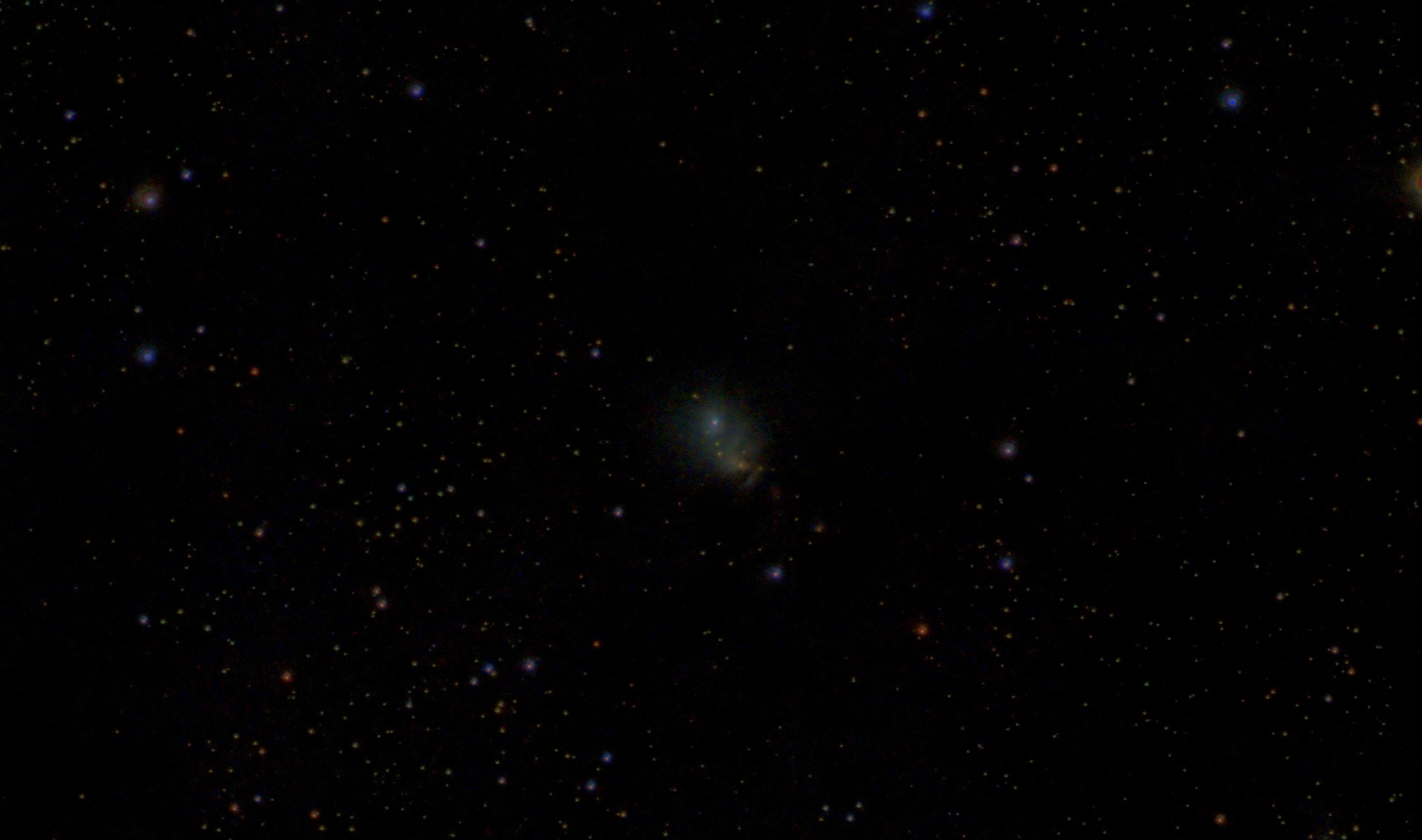 The small blue-green reflection nebula NGC 1333 in a dense field of stars
