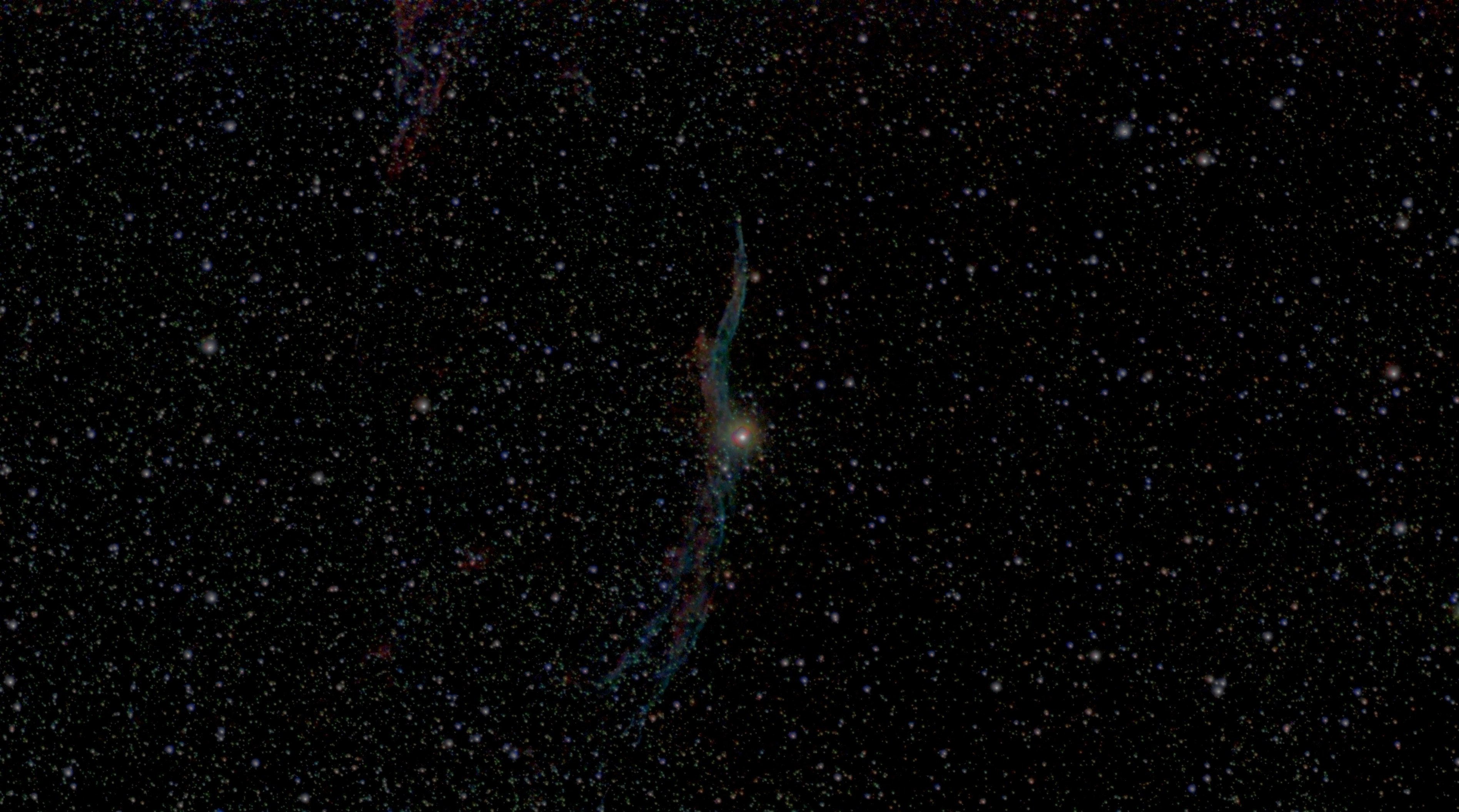 Thin red and blue-green filaments of the Western Veil Nebula passing through the bright star 52 Cygni